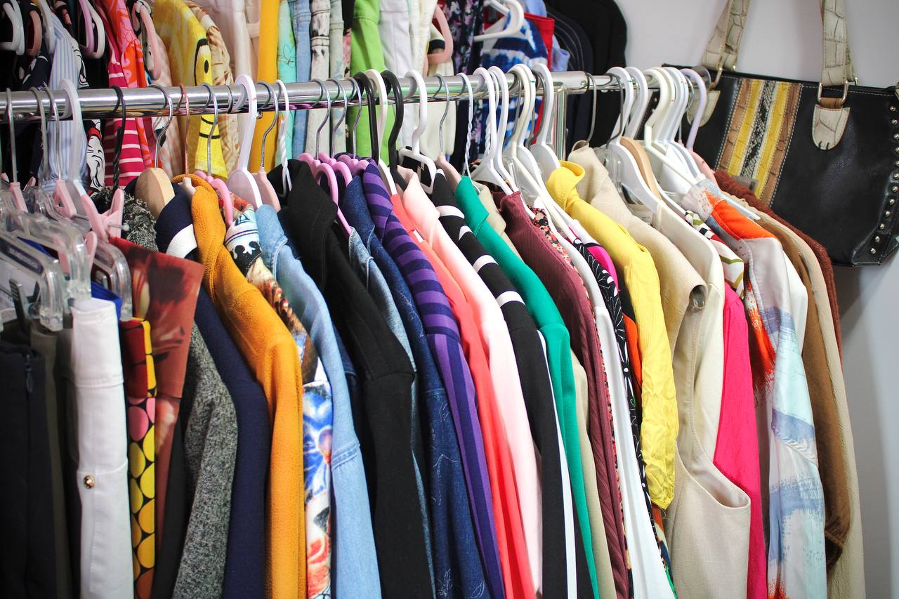 Clientes et équipe autour d’un présentoir de vêtements lors d’un événement LMRC.